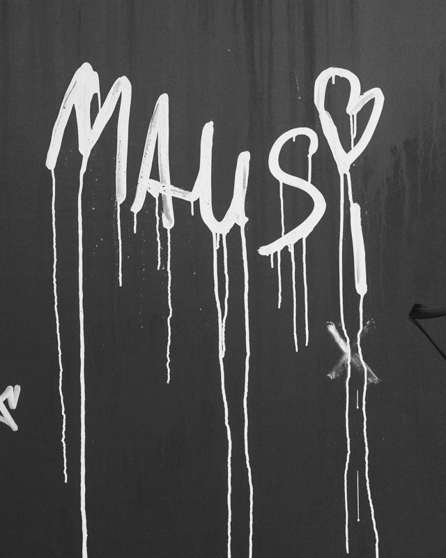 Detail am Mäusebunker Berlin: weißes Graffiti „MAUS" mit Herz, in Farbnasen über verwitterten Sichtbeton gelaufen – Spur der Aneignung an einem leerstehenden Brutalismus-Bau, Schwarzweiß